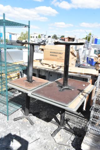 Four dining height tables with metal bases and square tops, shown in a used condition.
