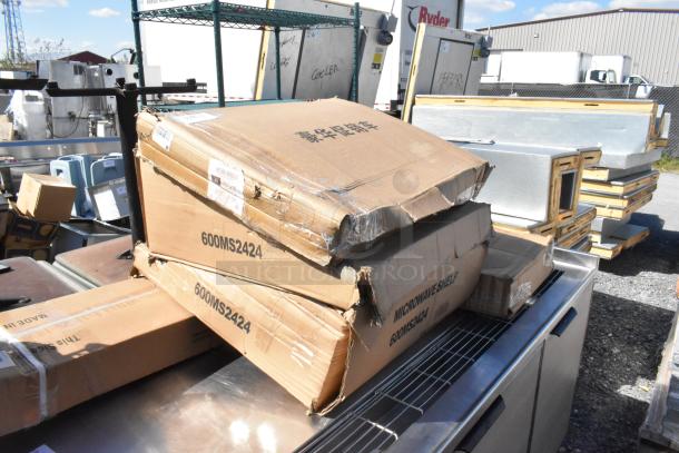 Boxes labeled "600MS2424" and "Microwave Shelf" Regency items in warehouse. Boxes are scratch and dented.