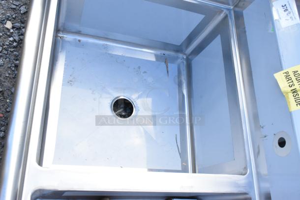 Brand new Regency 600S32424 stainless steel 3 bay sink with visible scratch and dent; tags indicate additional parts inside.