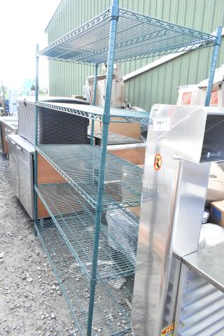 Green 5-tier wire shelving unit, undismantled, metal construction, industrial setting. Buyer must dismantle for shipping.