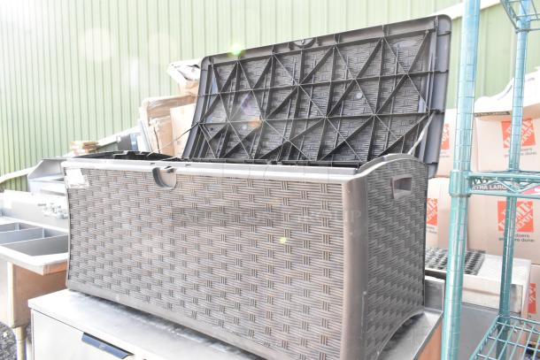 Poly outdoor storage box with woven pattern, open lid, durable construction. Used condition, suitable for patio storage.