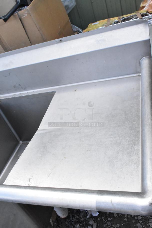 Stainless steel commercial 3 bay sink with dual drain boards, durable condition, ideal for kitchen or restaurant use.