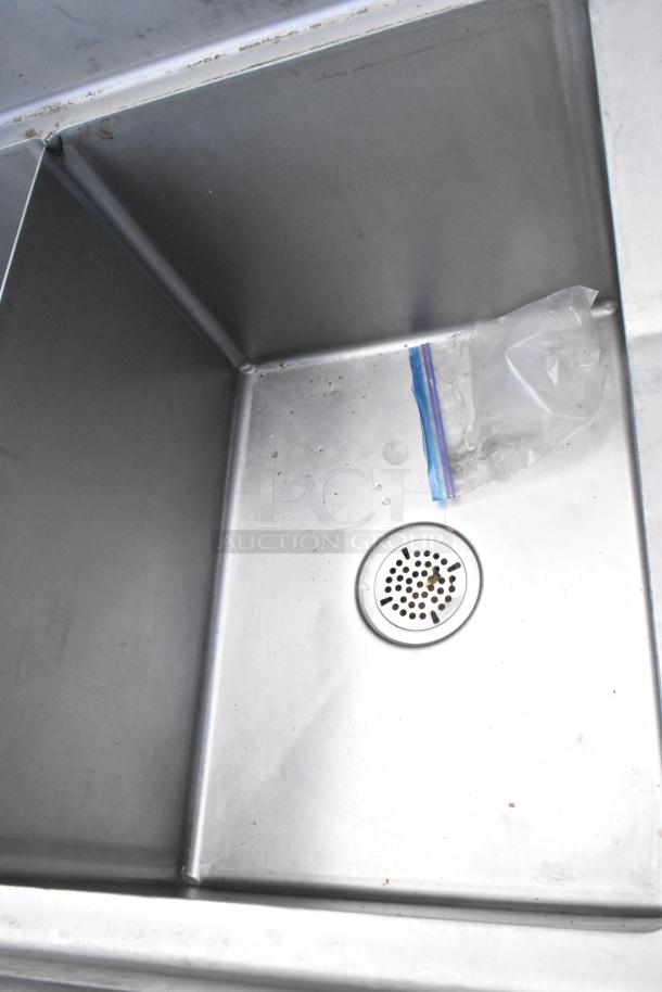 Stainless steel commercial 3 bay sink with dual drain boards, showing clean, intact condition with visible drain detail.