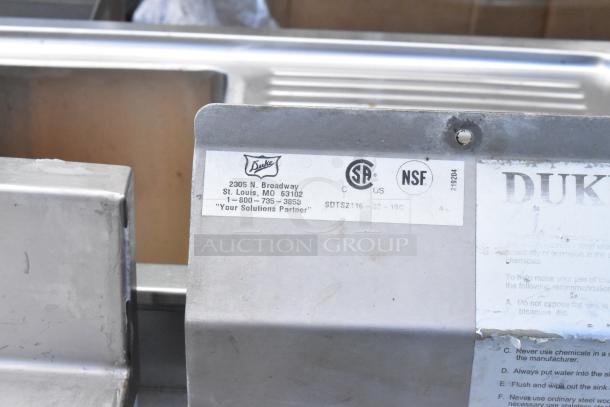 Stainless steel commercial 3 bay sink with dual drain boards. Duke label, CSA, NSF certified. Model SDTS2116-32-18C.