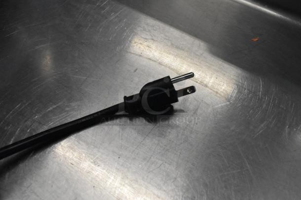 Black power cord for Avantco 177RWB92W rice warmer. Standard plug on metallic surface.