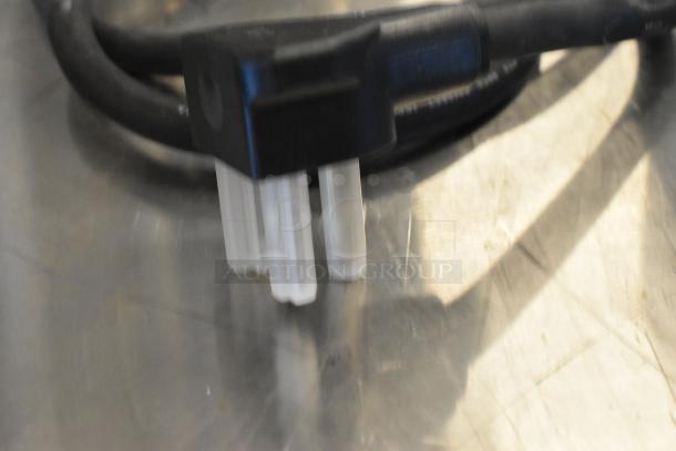 Close-up of a power cable connector for the Avantco 177CER400 electric range on a stainless steel surface.