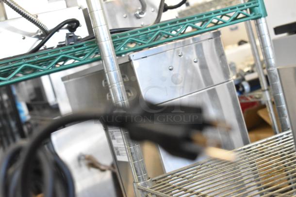 Blurred image of kitchen equipment including shelves with cables; not clearly displaying items Waring WSB35 blender or Galaxy vacuum machine.