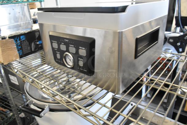 Brand new Galaxy 177GVMC10P chamber vacuum packing machine on a shelf; stainless steel with control panel.
