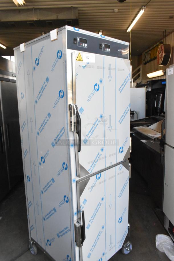 BRAND NEW Alto Shaam stainless steel heated holding cabinet, two half doors, on commercial casters, protective film.