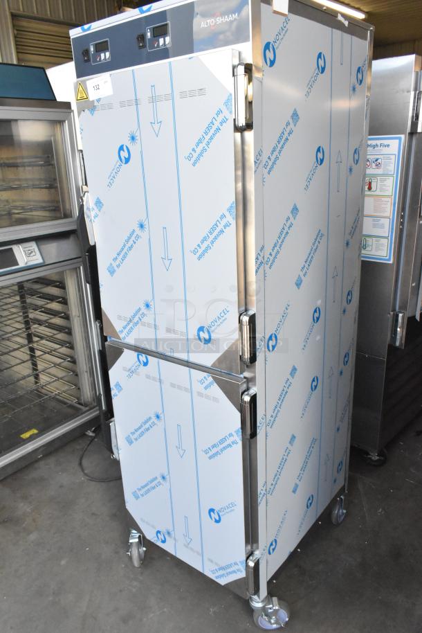 Brand new Alto Shaam stainless steel heated holding cabinet with two half-size doors, commercial casters, protective covering.