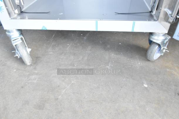 Brand new Alto Shaam stainless steel heated holding cabinet with two half-size doors. Visible scratches, commercial casters.