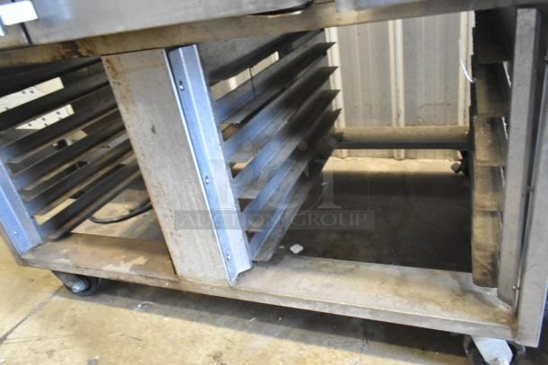 Baxter stainless steel rotating rack oven on double pan rack. Natural gas powered, on commercial casters. Slight wear visible.