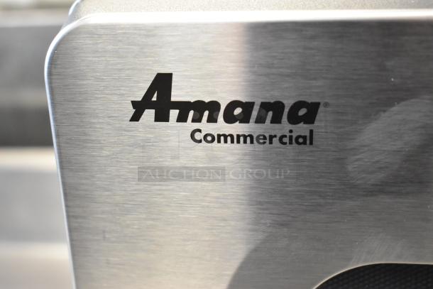 Amana RMS10DSA stainless steel commercial microwave in original box; 120V, 1 phase, pristine condition, Amana logo visible.