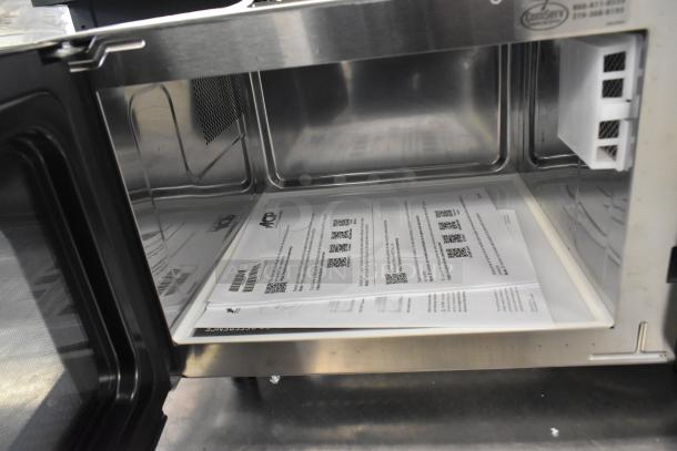 Amana RMS10DSA stainless steel commercial countertop microwave in original box, includes visible manuals, 120 volts, 1 phase.