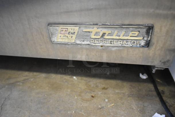 True TWT-72 stainless steel commercial 3-door undercounter cooler on casters. Features 115 volts, 1 phase. Label indicates model and make.