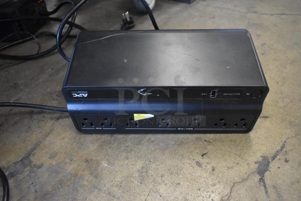 APC Back-UPS 600 Uninterruptible Power Supply, black, surface scratches, multiple outlets, label indicating power rating.