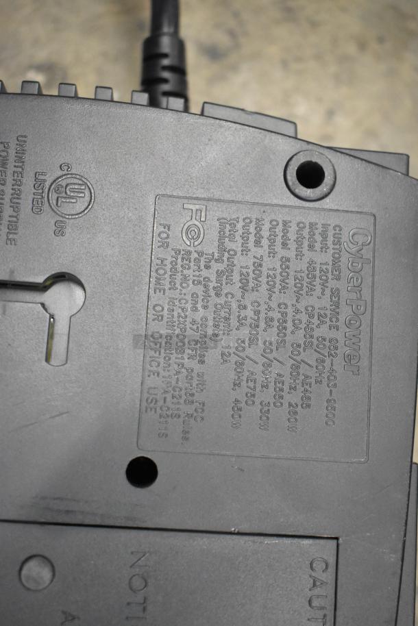 Close-up of CyberPower uninterruptible power supply label showing model, voltage, and compliance information; part of auction lot.