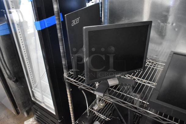 Four computer monitors including Lenovo, Dell, and Acer. Monitors on metal rack. Pick-up required, no shipping.