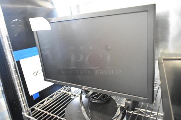 Acer computer monitor, black frame, on a metal shelf. Visible loose cables. Condition appears used.