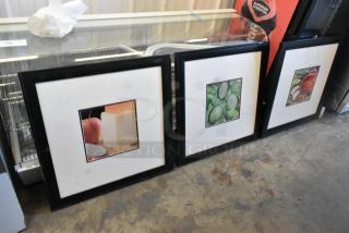 Three framed pictures featuring salad items: cheese, cucumbers, and tomatoes. Black frames, good condition.