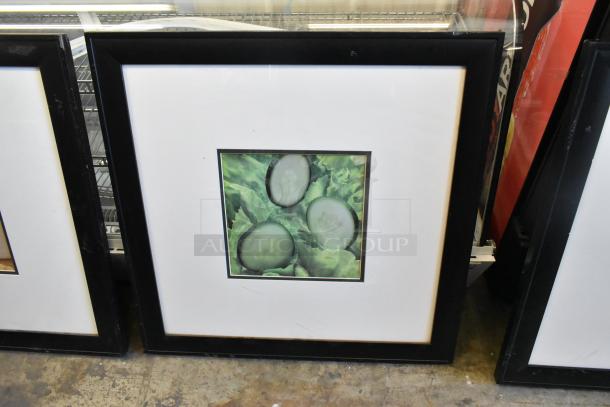 Framed picture of sliced cucumbers on lettuce. Black frame, good condition. Part of a set, bid includes three items.