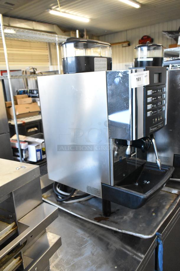 Faema stainless steel commercial countertop automatic espresso machine with steam wand, visible control panel, and ID label.