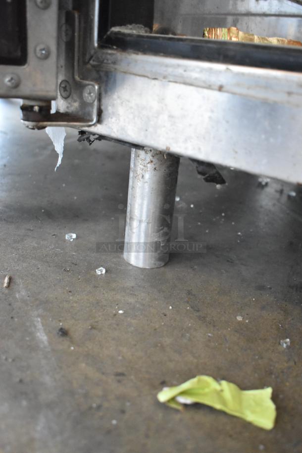 Perlick BR48 stainless steel undercounter cooler leg, slightly worn, visible on concrete floor. Appears stable and sturdy.