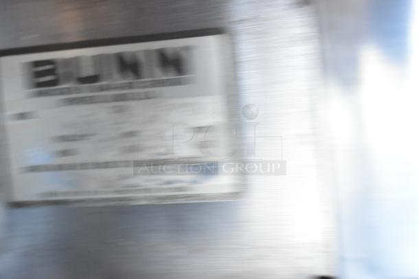 Bunn metal commercial coffee grinder, 120V, 1-phase. Visible label indicates brand and specifications.