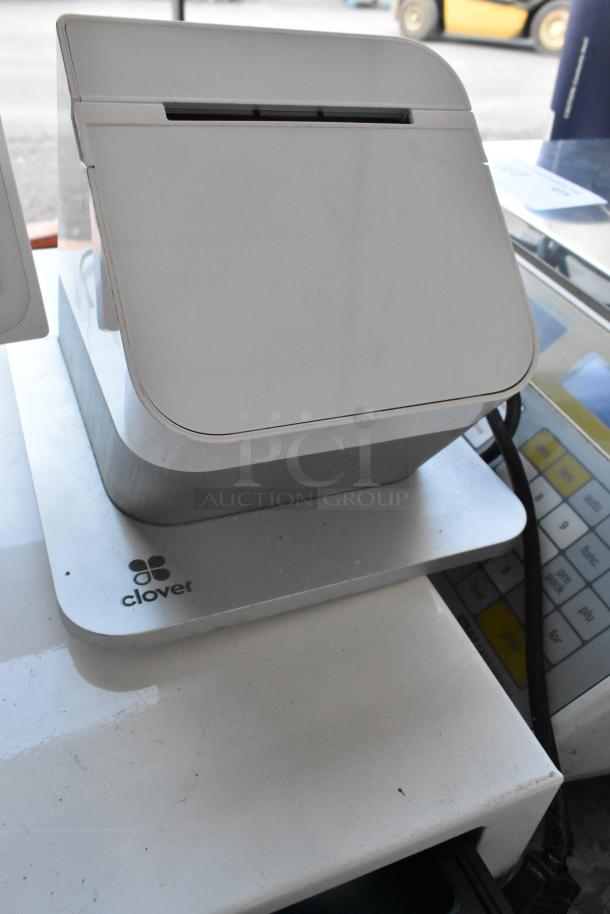 Clover POS System with monitor, receipt printer, and cash drawer. Features sleek design, visible logo, and in good condition.