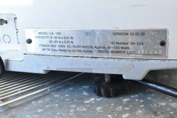 Easy Weigh LS-100 metal countertop scale, showing model, capacity, and power specifications on metal label. 240 volts, 1 phase.