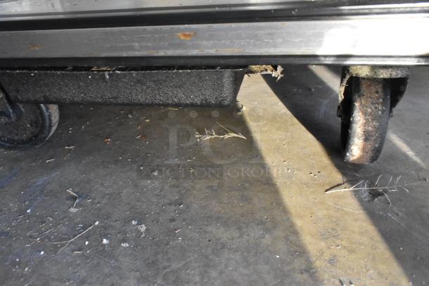 True TSSU-27-12M-B stainless steel prep table, visible rust on commercial casters, 115V, 1 phase.