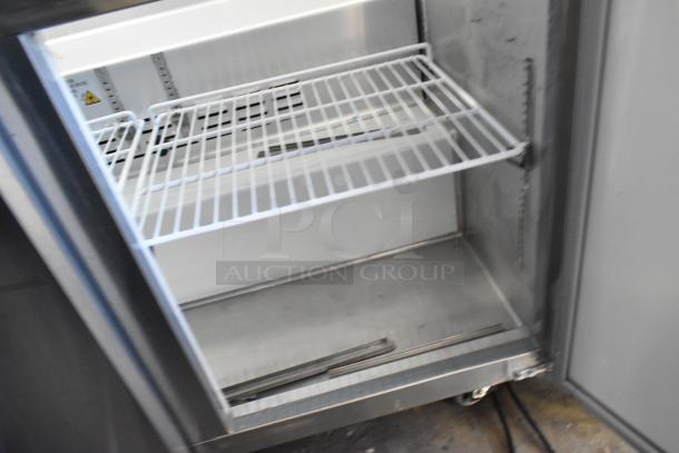 Motak MST-48-X stainless steel commercial prep table, showing interior wire shelves. Model and details inside. Used condition.