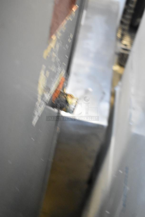 Blurry image of MagiKitch'n 636 stainless steel commercial charbroiler grill. Details are unclear.