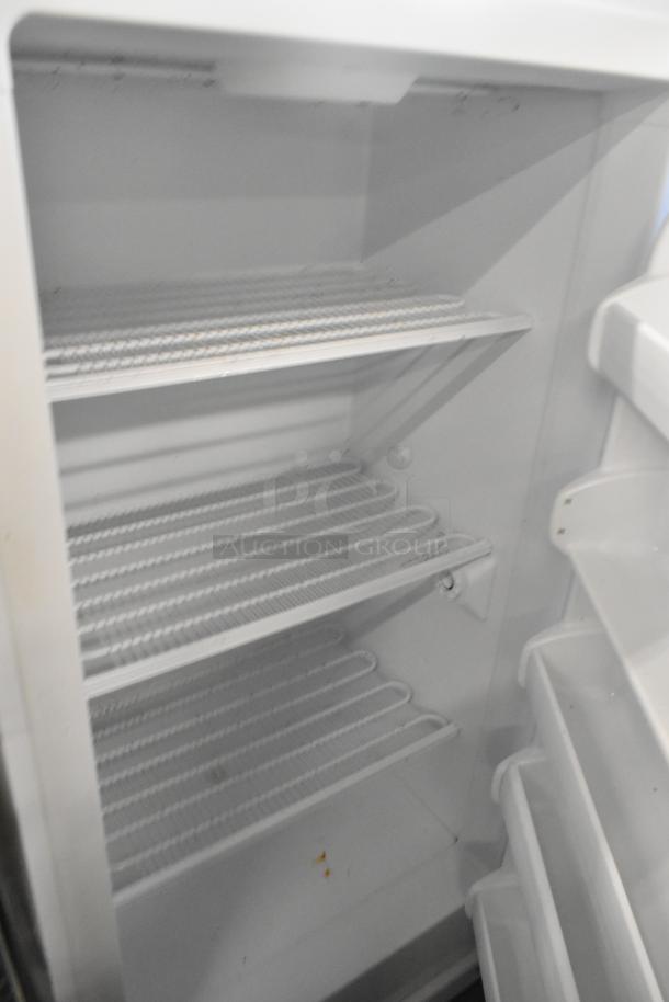 Kenmore metal single door reach-in freezer, 115 volts, 1 phase. Features adjustable wire shelving, clean interior, good condition.