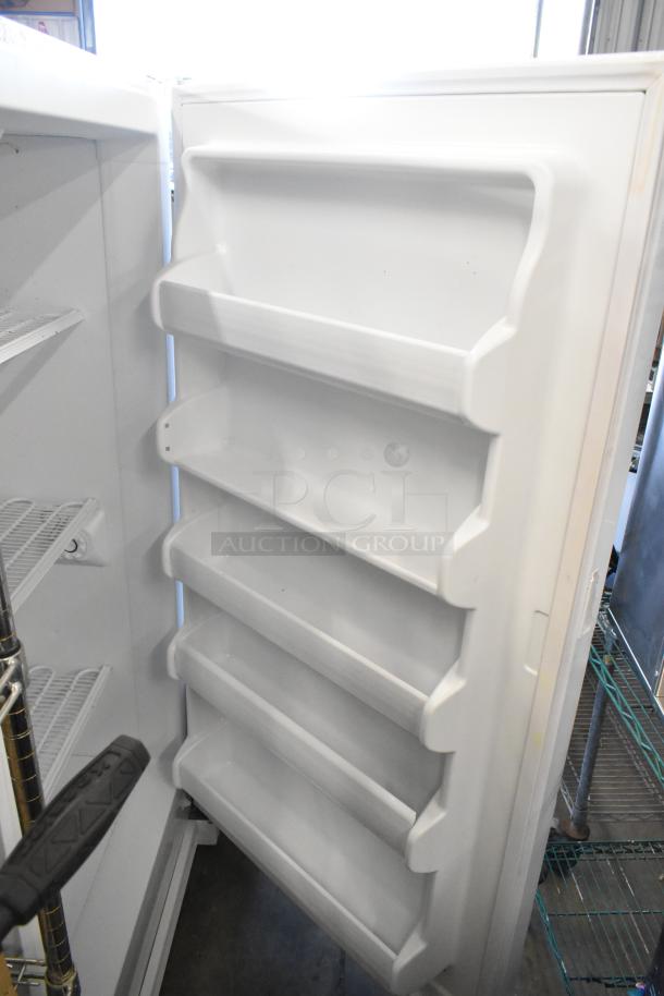 Kenmore metal single door reach-in freezer, 115 volts, 1 phase, features interior storage shelves, excellent condition.