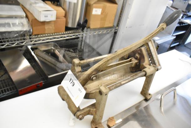 Metal countertop French fry cutter with sturdy handle, moderate wear. Tag marked "179" indicating auction lot number.