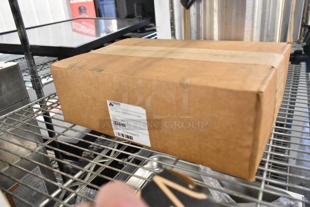 Box labeled "Prince Castle Single Function 4 Channel Timer" on a metal shelf, part of a mixed lot including a Tripp Lite unit.