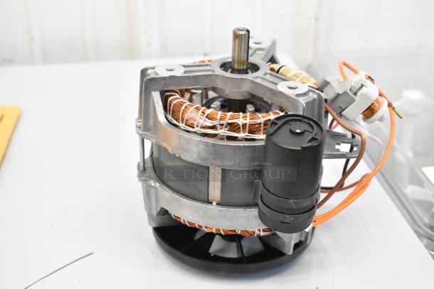 Electric motor with copper windings, metal frame, and attached wiring. Good condition, no visible labels.