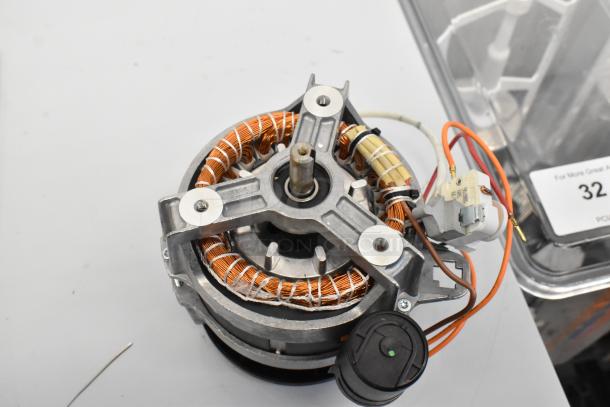 Electric motor with exposed copper coils, robust metal frame, showing wiring and connectors. In good condition.