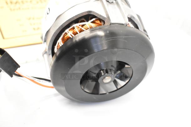 Electric motor with exposed copper winding, black fan, and attached wiring, in good condition. Suitable for auction.