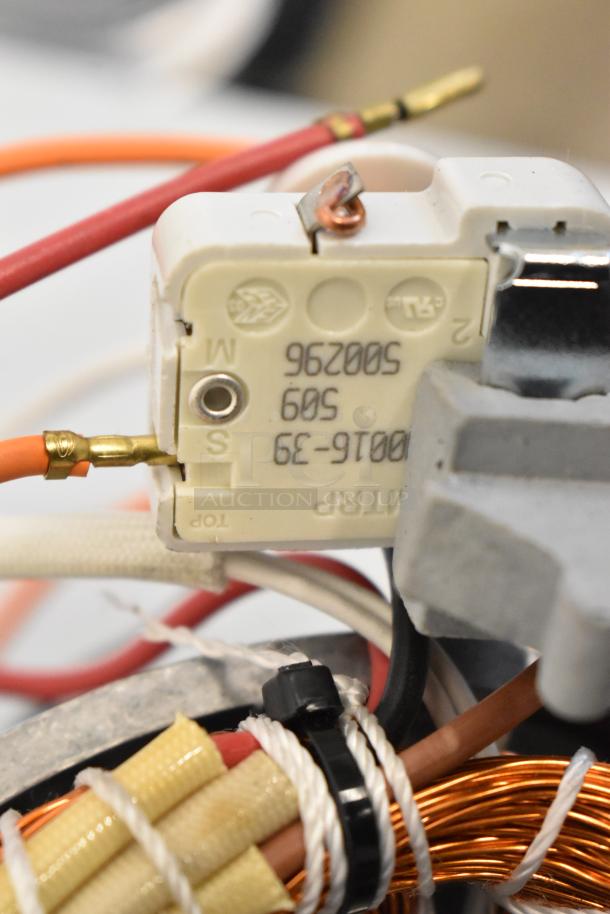 Close-up of a motor component showing wiring and copper coils. Markings include "MATRP" and "500296 5009 0016-39" on the label.