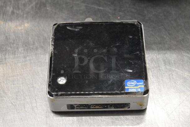 Intel NUC6i3SYK mini PC with visible wear, featuring Intel Core i3 inside sticker.
