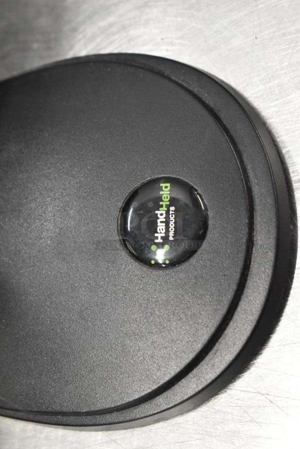 Close-up of a black barcode stand with a "Hand Held Products" logo, part of a Lenovo computer monitor setup.