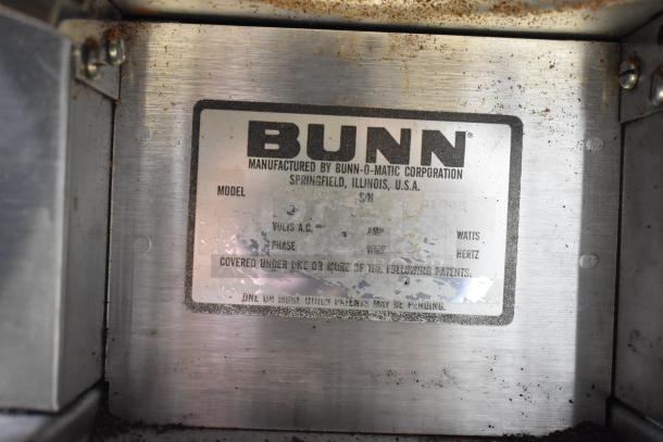 Bunn metal commercial countertop coffee bean grinder with visible label showing Bunn-O-Matic Corporation details. 120V, 1 phase.