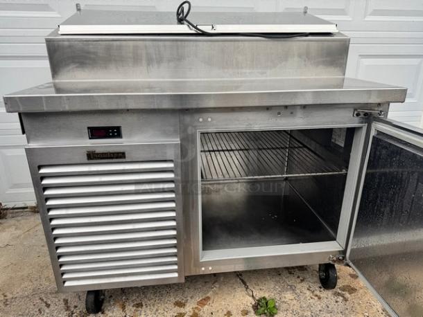 Traulsen 48" pizza prep table on casters, model TS048HT, 115V. Stainless steel, tested, working, with digital display and interior shelving.