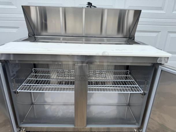 AVANTCO 2 Door Sandwich Table, model 178SCL2, on casters. Tested, working, open top, internal shelving visible. 115V.