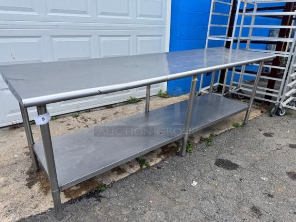 8ft stainless steel work table with undershelf, good condition, industrial use, visible tag marked with number 9.