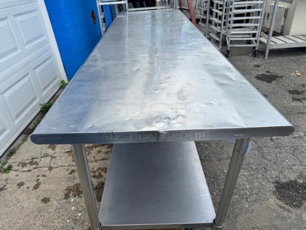 8Ft stainless steel work table with undershelf, minor surface dents, industrial-grade, ideal for kitchen or workshop use.