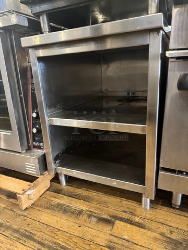 Stainless steel stand with two shelves, in good condition, suitable for kitchen use, features sturdy construction and clean finish.