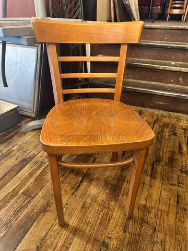 Wooden chair with ladder-back design, model BIDX4. Medium finish, solid hardwood, gently used condition, no visible wear.